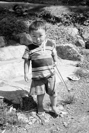 LAO CHAI, VIETMAN - SEP 12, 2014: Unidentified Black Hmong boy with a bow in Lao Chai,  Vietnam. Hmong is a ethnic minority in Vietnamのeditorial素材