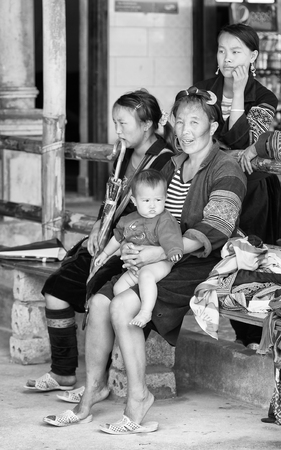 SAPA, VIETMAN - SEP 22, 2014: Unidentified Hmong woman carries her baby in Sapa, Vietnam. Hmong is a minority ethnic group of Vietnamのeditorial素材