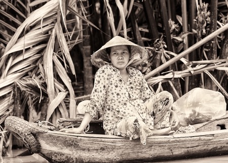 HO CHI MIN, VIETMAN - OCT 4, 2014: Unidentified Vietnamese woman in a rice hat portrait in Saigon, Vietnam. 86 of Vietnamese people belong to the Viet ethnic groupのeditorial素材