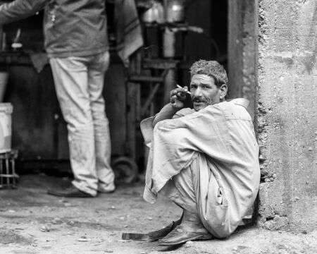 ASWAN, EGYPT - DEC 2, 2014: Unidentified Egyptian man smoke in the street. 90 of Egyptian people are Muslimのeditorial素材