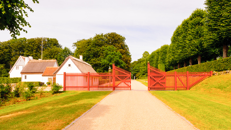 Small houses and the red fence in the park behind the Castle in Denmarkの写真素材