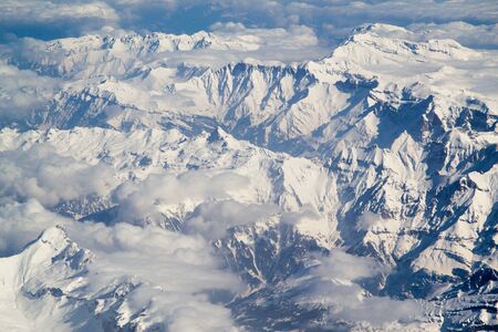 Beautiful panorama of the Alps covered with snow and cloudsの写真素材