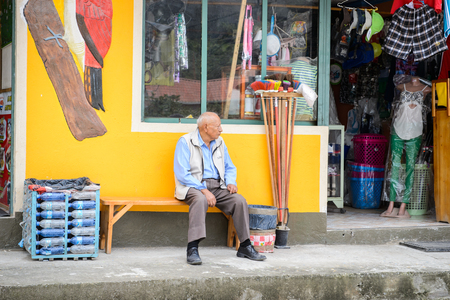 MINDO, ECUADOR - JAN 1, 2015: Unidentified Ecuadorian man sits near a shop. 71,9% of Ecuadorian people belong to the Mestizo ethnic groupのeditorial素材