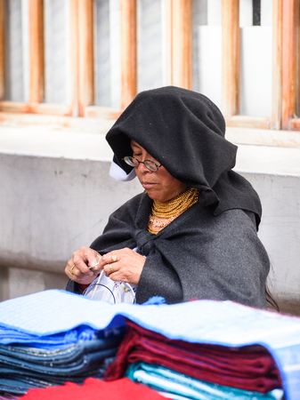 OTAVALO, ECUADOR - JAN 3, 2015: Unidentified Ecuadorian woman sews  at the Otavalo Market. 71,9% of Ecuadorian people belong to the Mestizo ethnic groupのeditorial素材