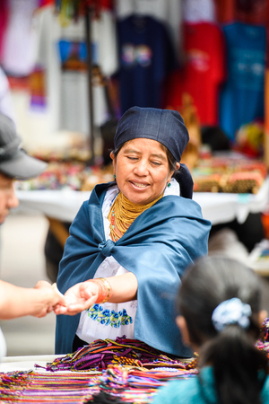 OTAVALO, ECUADOR - JAN 3, 2015: Unidentified Ecuadorian woman in traditional clothes works at the Otavalo Market. 71,9% of Ecuadorian people belong to the Mestizo ethnic groupのeditorial素材