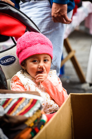 OTAVALO, ECUADOR - JAN 3, 2015: Unidentified Ecuadorian cute little girl in a hat in a baby carriage. 71,9% of Ecuadorian people belong to the Mestizo ethnic groupのeditorial素材