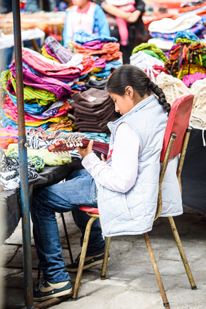 OTAVALO, ECUADOR - JAN 3, 2015: Unidentified Ecuadorian girls work at the Otavalo Market. 71,9% of Ecuadorian people belong to the Mestizo ethnic groupのeditorial素材