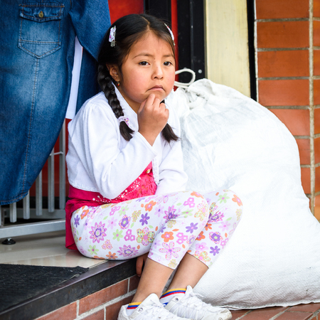 OTAVALO, ECUADOR - JAN 3, 2015: Unidentified Ecuadorian girls sits at the Otavalo Market. 71,9% of Ecuadorian people belong to the Mestizo ethnic groupのeditorial素材