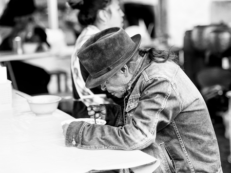 QUITO, ECUADOR - JAN 1, 2015: Unidentified Ecuadorian woman in a traditional bowler hat eats soup. 71,9% of Ecuadorian people belong to the Mestizo ethnic groupのeditorial素材