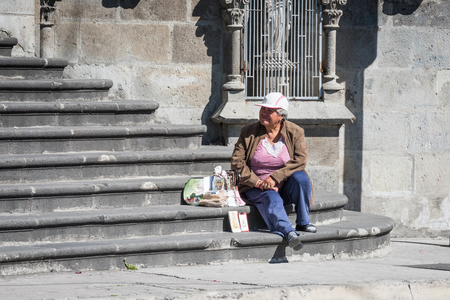 QUITO, ECUADOR - JAN 2, 2015: Unidentified Ecuadorian woman sits on the stairs. 71,9% of Ecuadorian people belong to the Mestizo ethnic groupのeditorial素材