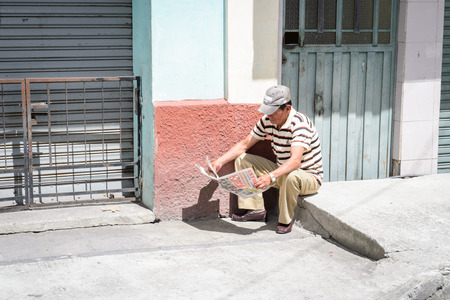 RIOBAMBA, ECUADOR - JAN 7, 2015: Unidentified Ecuadorian man reads a newspaper. 71,9% of Ecuadorian people belong to the Mestizo ethnic groupのeditorial素材