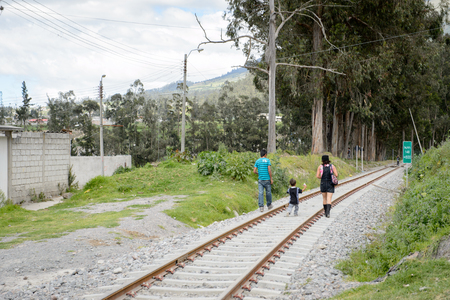 OTAVALO, ECUADOR - JAN 3, 2015: Unidentified Ecuadorian man, woman and a boy walk on the railroad. 71,9% of Ecuadorian people belong to the Mestizo ethnic groupのeditorial素材