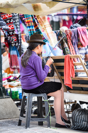 OTAVALO, ECUADOR - JAN 3, 2015: Unidentified Ecuadorian woman in traditional clothes works at the Otavalo Market. 71,9% of Ecuadorian people belong to the Mestizo ethnic groupのeditorial素材