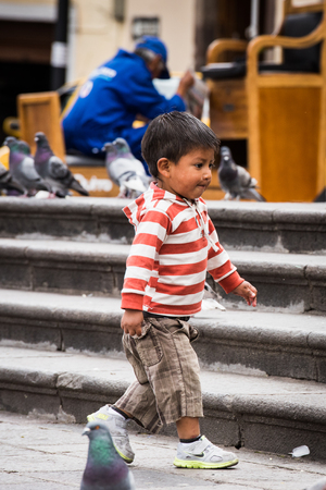 QUITO, ECUADOR - JAN 2, 2015: Unidentified Ecuadorian little boy plays on a the square. 71,9% of Ecuadorian people belong to the Mestizo ethnic groupのeditorial素材