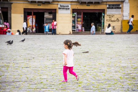 QUITO, ECUADOR - JAN 2, 2015: Unidentified Ecuadorian girls runs in the street. 71,9% of Ecuadorian people belong to the Mestizo ethnic groupのeditorial素材
