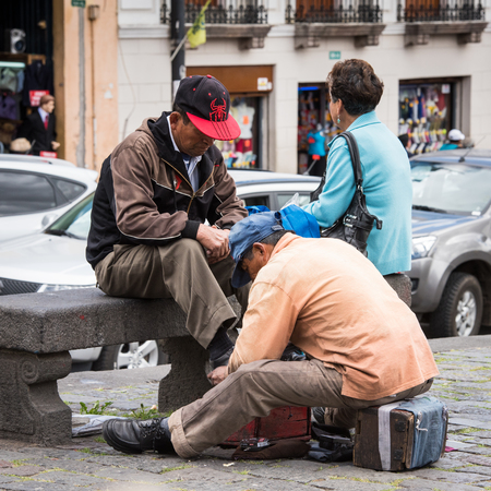 QUITO, ECUADOR - JAN 2, 2015: Unidentified Ecuadorian man cleans shoes. 71,9% of Ecuadorian people belong to the Mestizo ethnic groupのeditorial素材