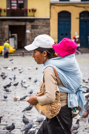 QUITO, ECUADOR - JAN 2, 2015: Unidentified Ecuadorian woman carries her baby. 71,9% of Ecuadorian people belong to the Mestizo ethnic groupのeditorial素材