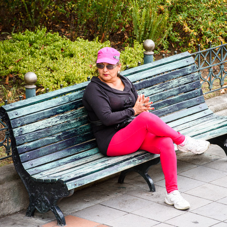 CUENCA, ECUADOR - JAN 9, 2015: Unidentified Ecuadorian woman on a bench. 71,9% of Ecuadorian people belong to the Mestizo ethnic groupのeditorial素材