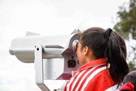 CUENCA, ECUADOR - JAN 9, 2015: Unidentified Ecuadorian girl looks through the telescope. 71,9% of...