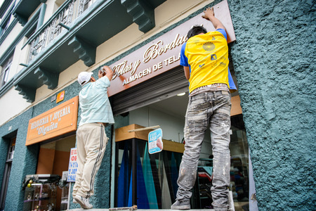 CUENCA, ECUADOR - JAN 9, 2015: Unidentified Ecuadorian men work in  the street. 71,9% of Ecuadorian people belong to the Mestizo ethnic groupのeditorial素材