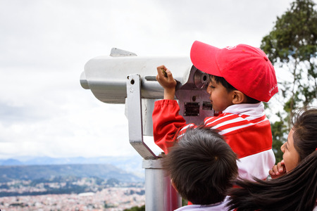 CUENCA, ECUADOR - JAN 9, 2015: Unidentified Ecuadorian boy looks through the telescope. 71,9% of Ecuadorian people belong to the Mestizo ethnic groupのeditorial素材