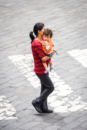 CUENCA, ECUADOR - JAN 9, 2015: Unidentified Ecuadorian woman carries her baby. 71,9% of Ecuadorian people belong to the Mestizo ethnic groupのeditorial素材