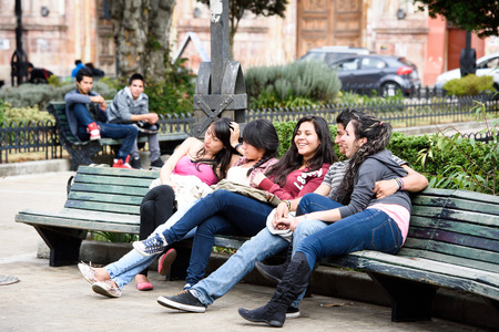 CUENCA, ECUADOR - JAN 9, 2015: Unidentified Ecuadorian girls sit on the bench. 71,9% of Ecuadorian people belong to the Mestizo ethnic groupのeditorial素材