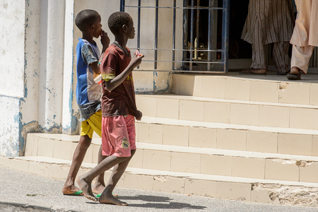 SAINT LOUIS, SENEGAL - APR 24, 2017: Unidentified Senegalese two boys walk along the street in the centre of Saint Louis, one of the major cities in Senegalのeditorial素材