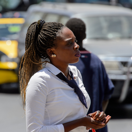 SAINT LOUIS, SENEGAL - APR 24, 2017: Unidentified Senegalese woman with braids walks along the street in the centre of Saint Louis, one of the major cities in Senegalのeditorial素材