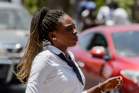 SAINT LOUIS, SENEGAL - APR 24, 2017: Unidentified Senegalese woman with braids walks along the street in the centre of Saint Louis, one of the major cities in Senegalのeditorial素材