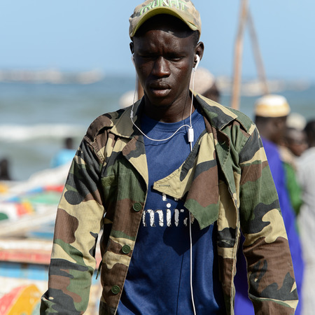 KAYAR, SENEGAL - APR 27, 2017: Unidentified Senegalese man listens to the music on the coast of the Atlantic Ocean. Many Kayar people work in portのeditorial素材