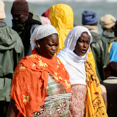 KAYAR, SENEGAL - APR 27, 2017: Unidentified Senegalese women walk on the coast of the Atlantic Ocean. Many Kayar people work in portのeditorial素材