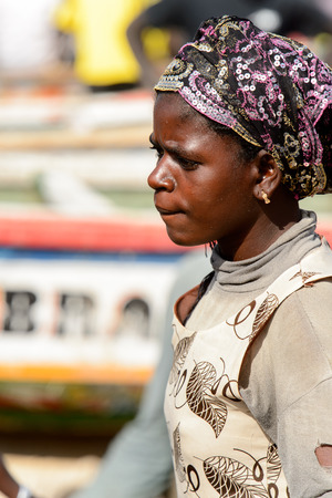 KAYAR, SENEGAL - APR 27, 2017: Unidentified Senegalese woman in headscarf frowns on the coast of the Atlantic Ocean. Many Kayar people work in portのeditorial素材