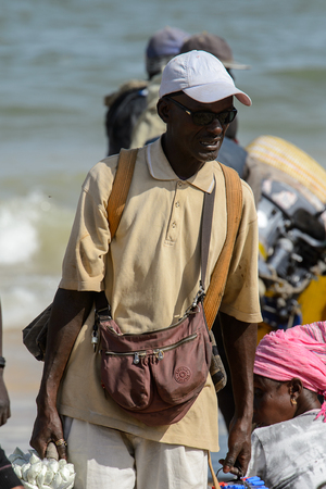 KAYAR, SENEGAL - APR 27, 2017: Unidentified Senegalese man walks on the coast of the Atlantic Ocean. Many Kayar people work in portのeditorial素材