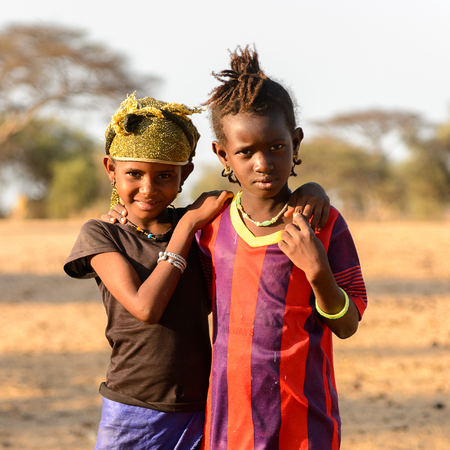 FERLO DESERT, SENEGAL - APR 25, 2017: Unidentified Fulani two girls hug each other on the street. Fulanis (Peul) are the largest tribe in West African savannahsのeditorial素材