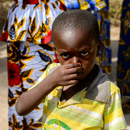 KASCHOUANE, SENEGAL - APR 29, 2017: Unidentified Diola little boy wipes his nose in Kaschouane village. Diolas are the ethnic group predominate in the region of Casamanceのeditorial素材