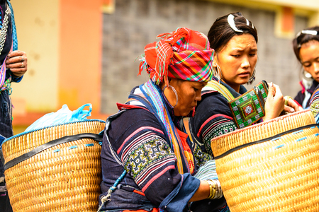 SAPA, VIETNAM - SEP 20, 2014: Unidentified Hmong woman wearing the traditional costume to attract the tourists and red kerchief . Hmong people is a minority ethnic group living in Sapaのeditorial素材