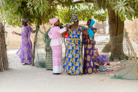 KASCHOUANE, SENEGAL - APR 29, 2017: Unidentified Diola women in traditional clothes talk about something in Kaschouane village. Diolas are the ethnic group predominate in the region of Casamanceのeditorial素材