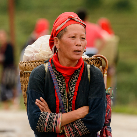 TA PHIN, LAO CAI, VIETNAM - SEP 21, 2014: Unidentified Red Dao woman in a red kerchief with stuff to sell in the Ta Phin village. Red Dao is one of the minority ethnic groups in Vietnamのeditorial素材