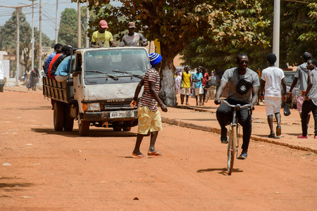 CANCHUNGO, GUINEA BISSAU - MAY 3, 2017: Unidentified local man rides a bicycle in the centre of Canchungo, one of the major cities of the countryのeditorial素材