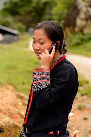 TA PHIN, LAO CAI, VIETNAM - SEP 21, 2014:  Unidentified Red Dao girl speaks on a cell phone in the Ta Phin village. Red Dao is one of the minority ethnic groups in Vietnamのeditorial素材
