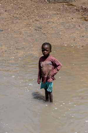 CANHABAQUE, GUINEA BISSAU - MAY 4, 2017: Unidentified local little boy puts his hand on a hip in a village of the Canhabaque island. People in G.-Bissau still suffer of povertyのeditorial素材