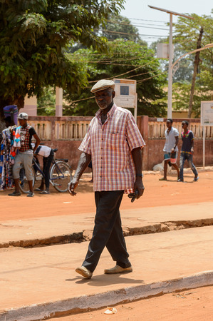 CANCHUNGO, GUINEA BISSAU - MAY 3, 2017: Unidentified local old man walks along the road in the centre of Canchungo, one of the major cities of the countryのeditorial素材