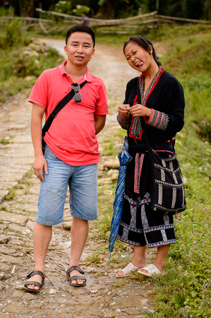 TA PHIN, LAO CAI, VIETNAM - SEP 21, 2014:  Unidentified Red Dao girl with a tourist in the Ta Phin village. Red Dao is one of the minority ethnic groups in Vietnamのeditorial素材