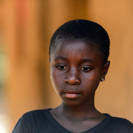 CANHABAQUE, GUINEA BISSAU - MAY 4, 2017: Unidentified local girl looks down in a village of the Canhabaque island. People in G.-Bissau still suffer of povertyのeditorial素材