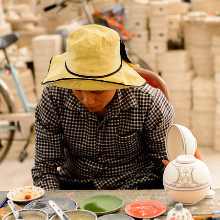 HANOI, VIETNAM - SEP 24, 2014: Unidentified Vietnamese man works at the ceramic workshop. Ceramic art is very popular in Asian cultureのeditorial素材