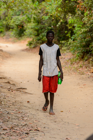 SOGA, GUINEA BISSAU - MAY 5, 2017: Unidentified local man walks along the street in a village of the Soga island. People in G.-Bissau still suffer of povertyのeditorial素材
