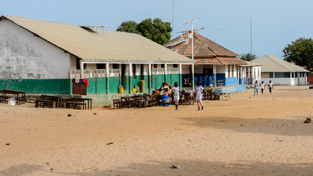 ORANGO ISLAND, GUINEA BISSAU - MAY 3, 2017: Unidentified local women walk along the street in the Etigoca village. People in G.-Bissau suffer of poverty due to the bad economyのeditorial素材