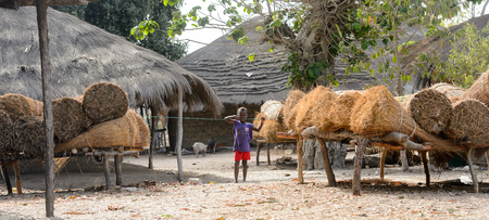 ORANGO ISLAND, GUINEA BISSAU - MAY 3, 2017: Unidentified local little boy holds on the rope in the Etigoca village. People in G.-Bissau suffer of poverty due to the bad economyのeditorial素材