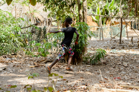 CANHABAQUE, GUINEA BISSAU - MAY 4, 2017: Unidentified local little girl runs along the street in a village of the Canhabaque island. People in G.-Bissau still suffer of povertyのeditorial素材